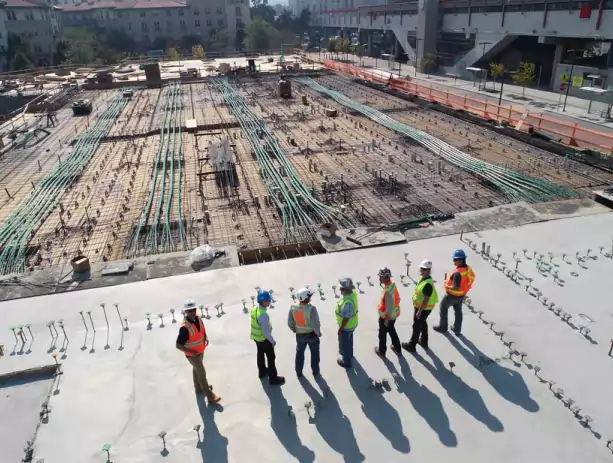 group of construction workers and engineers surveying a work site and planning